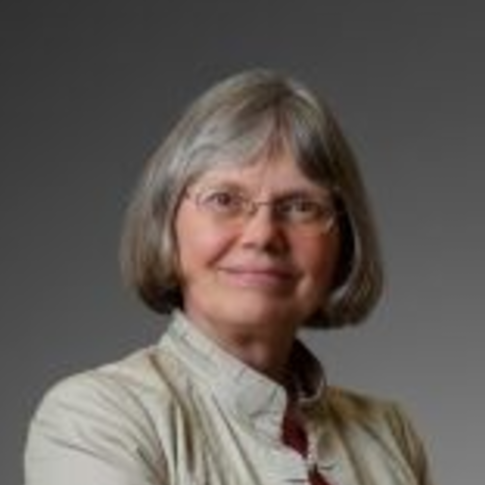 Portrait Kathleen B. Digre, weiblich lesbare, weisse Person mit mittellangen Haaren, Brille und weisser Bluse