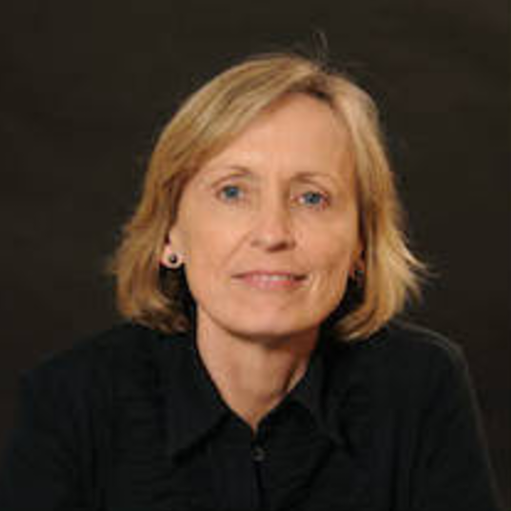 Portrait Sheila Laverty, weiblich lesbare, weisse Person mit mittellangem, blondem Haar, Ohrsteckern und schwarzer Bluse