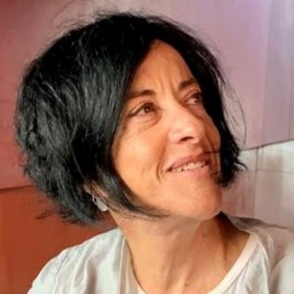 Portrait Tamar El-Or, weiblich lesbare, BIPoC-Person mit kurzen, schwarzen Haaren und weissem Oberteil