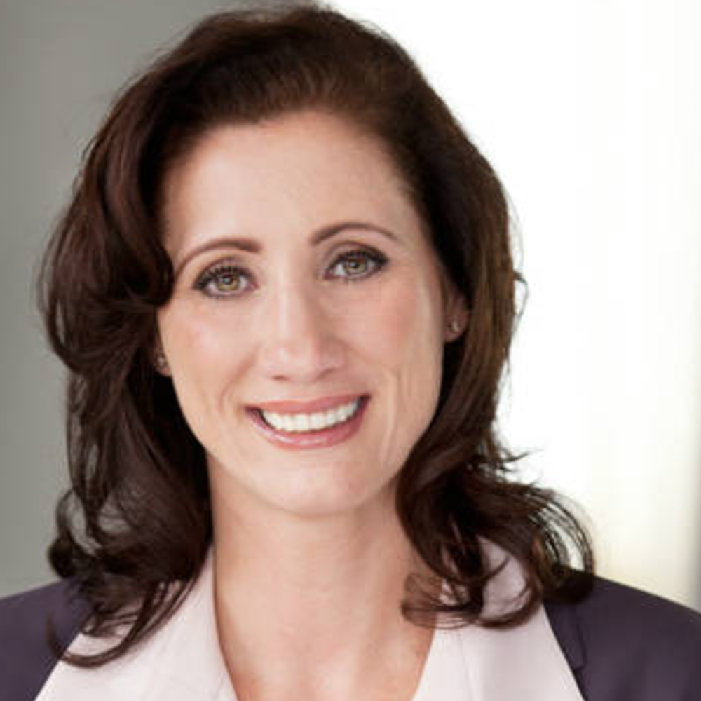 Portrait Janell D. Townsend, weiblich lesbare, weisse Person mit mittellangem Haar, Ohrsteckern, Bluse und Blazer